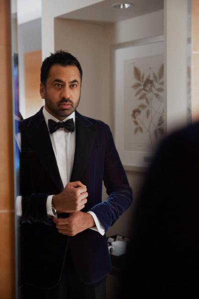 An image of actor, writer, and producer Kal Pen in a blue velvet suit in front of a mirror
